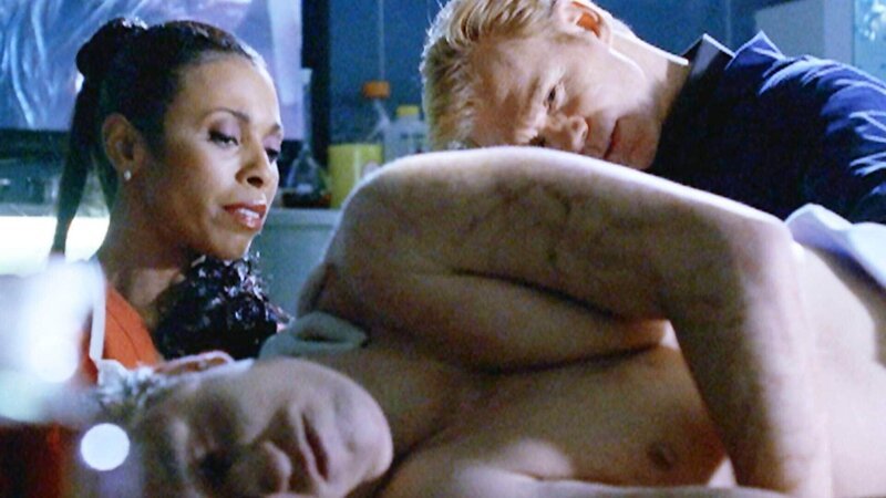 In der Gerichtsmedizin untersuchen Alexx (Khandi Alexander) und Horatio (David Caruso) den Toten. Sie drehen ihn herum und schauen sich die Stichverletzungen an, um die Todesursache zu ermitteln. – Bild: TVNOW /​ CBS