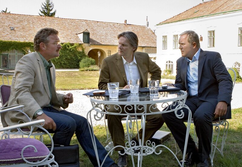 Jakob Ressler (Ferry Öllinger, links), der vorübergehend das Bürgermeisteramt des erkrankten Georg Plattner übernommen hat, lehnt jede Unterstützung des von Georg initiierten Wellness-Projekts durch die Stadtgemeinde Rust ab, nachdem er mit Thomas’ (Harald Krassnitzer, rechts) Hilfe Ungereimtheiten im Kaufvertrag für das Schloss Bergham entdeckt hat. Dessen Besitzer Andreas Koblenz (Max Herbrechter) droht ein lukratives Geschäft zu entgehen. – Bild: BR/​ARD/​ORF/​Georg Bodenstein