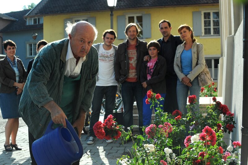Das schöne Blumenbeet ist der ganze Stolz von Pfarrer Kurz. Von links: Pfarrer Kurz (Hans Stadlbauer), Florian Brunner (Tommy Schwimmer), Gregor Brunner (Holger M. Wilhelm), Christian (Marinus Kaffl), Mike (Harry Blank) und Trixi Preissinger (Doreen Dietel). – Bild: BR/​Marco Orlando Pichler