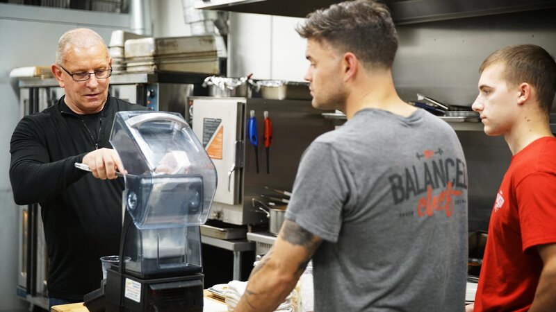 Chef Robert Irvine shows The Balanced Chef owner, Brian Donovan, along with kitchen manager, Kent Vedder, how to make new menu items, as seen on Restaurant Impossible, season 20 – Bild: TLC (DEUT)