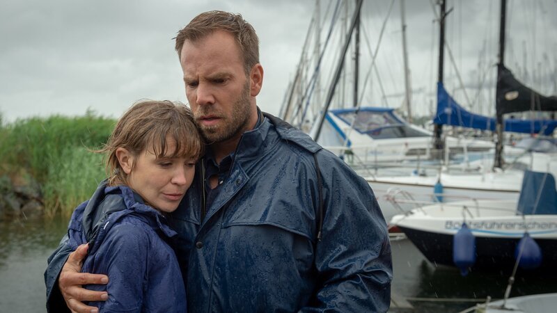 Astrid Lissek (Lea Faßbender, l.) ist vom Tod ihres Freundes Falk Petersen schwer getroffen. Lars Pöhlmann (Dominic Boeer, r.) gibt sich größte Mühe, die junge Frau zu trösten. Er erfährt von ihr, dass sie ihren Freund regelrecht gedrängt hat, sich als den Retter der Witwe Scherz zu offenbaren. Doch warum wollte der Tote seine Heldentat unbedingt geheim halten? – Bild: ZDF und Marc Meyerbroeker
