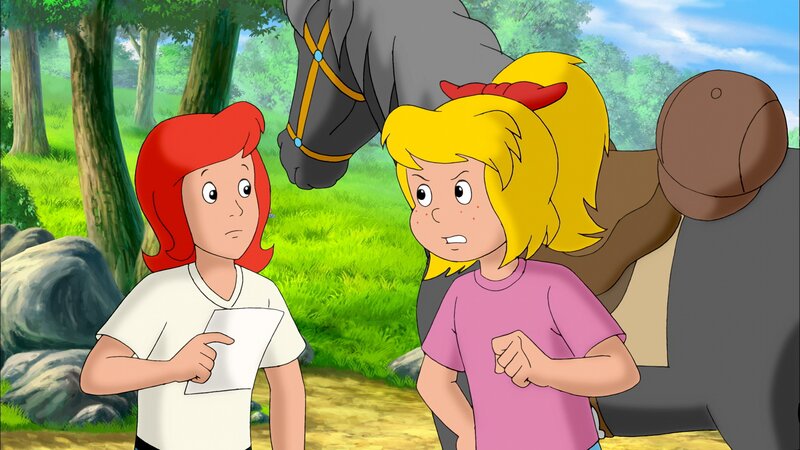 Bibi (r.) zeigt Tina (l.) eine Nachricht, in der steht, dass Sabrina erst freigelassen wird, wenn sie Regen hext. – Bild: ZDF/​Kiddinx – Berlin