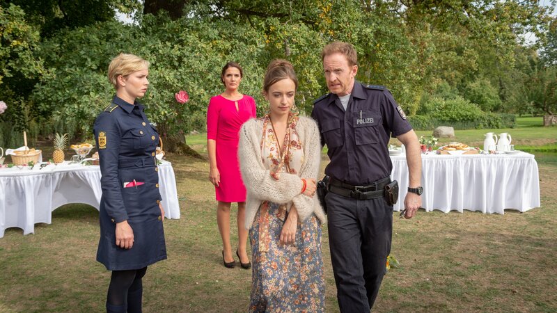Stine (Sidsel Hindhede, l.) und Timmermann (Mathias Junge, r.) hören sich unter den Hochzeitsgästen um. Alexandra Bremer (Nellie Thalbach, 2.v.r.) trifft der Tod ihres Bruders wie ein Schlag. Wieso sollte irgendjemand ihren Bruder töten wollen? Patentante Ramona Liehre (Anne von Linstow, 2.v.l.) liefert den Polizisten jedoch einen ersten Hinweis: Die Braut hat am Abend auch noch mit einem anderen Gast innig getanzt. – Bild: ZDF und Marc Meyerbröker