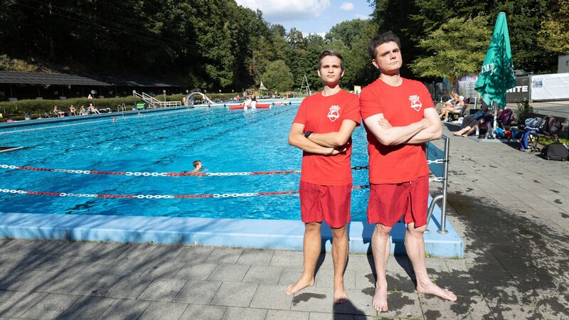 Fabian Köster (l.) und Lutz van der Horst (r.) posieren als „Wels Angels“ vor dem Schwimmbecken des Freibades Dabringhausen (Wermelskirchen), das durch eine Bürgerinitiative vor der Schließung gerettet wurde. – Bild: ZDF und Thomas Wolfschläger