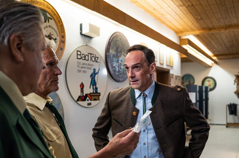 Hubert (Christian Tramitz, 2.v.l.) und Girwidz (Michael Brandner, l.) befragen den Vorsitzenden des Schützenvereins Benjamin Grasser (Harry Blank, r.). Hat er etwas mit dem Schusswechsel auf dem Friedhof zu tun? – Bild: ARD/​Jenrick Mielke