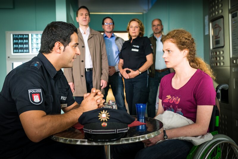 Tarik (Serhat Cokgezen, l.) versucht Tanja Sudmann (Anja Antonowicz, r.) klarzumachen, dass sie ihren Mann am besten schützen kann, wenn sie ihn dazu bringt, mit dem LKA-Ermittler Gerald Renner (Michael Ehnert, 2.v.l.) zu sprechen. – Bild: ZDF/​Boris Laewen