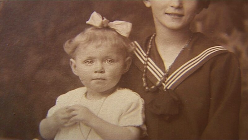 Ella und Fanni schauen sich gemeinsam mit ihrer Großmutter alte Fotoalben an. – Bild: WDR/​Die Sendung mit dem Elefanten