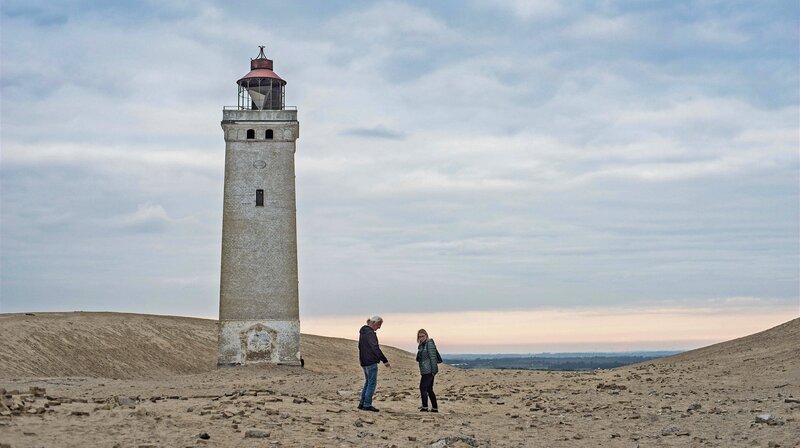 Die Urlaubschecker Ingrid und Matthias vor dem Leuchtturm Rubjerg Knude Fyr in Nordjütland. – Bild: NDR/​Linus Koch /​ NDR Presse und Information