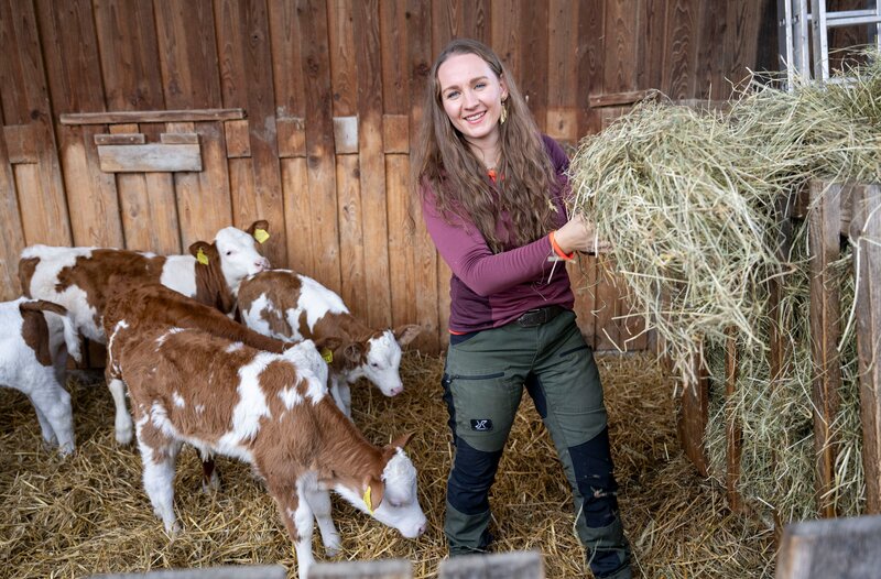 Verena Krimbacher füttert ihre Tiere mit frischem Heu. – Bild: WDR/​Melanie Grande