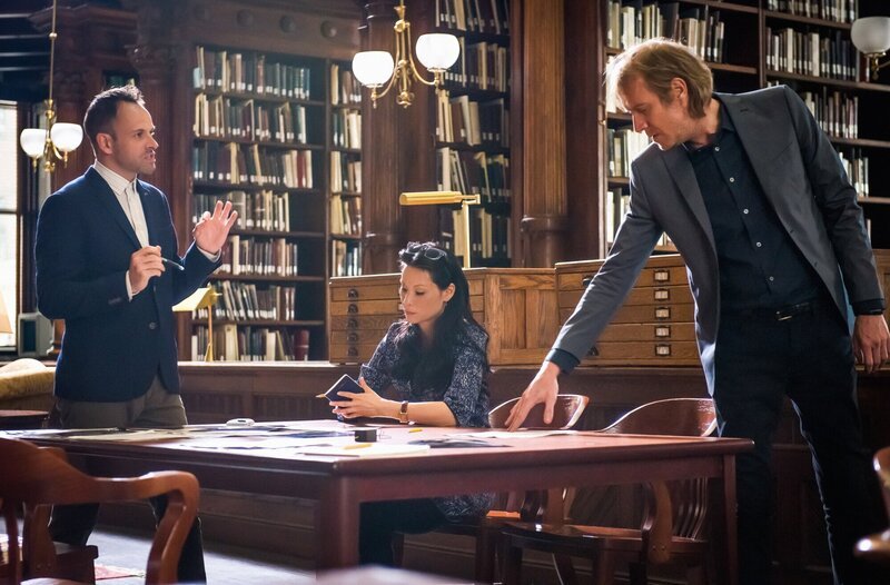 Brainstorming in der Bibliothek: Holmes (Jonny Lee Miller, l.), Watson (Lucy Liu, M.) und Mycroft (Rhys Ifans, r.) versuchen fieberhaft herauszufinden, wer der Maulwurf beim MI Six ist … – Bild: CBS Television