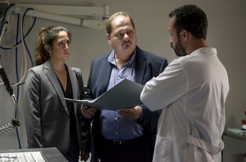 Silva (Jürgen Tarrach, li.) und Marcia (Vidina Popov) bekommen von einem Pathologen (Tiago Fernandes) einen wichtigen Hinweis. – Bild: PLURIMEDIA (ARD Degeto /​ Paulo Monteiro)