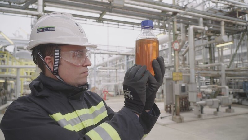 Dr. Ventsislav Mishev, OMV, mit einer Flasche altem Frittieröl. Am Flughafen Wien-Schwechat heben bereits Flugzeuge mit Frittieröl im Tank ab. – Bild: ServusTV