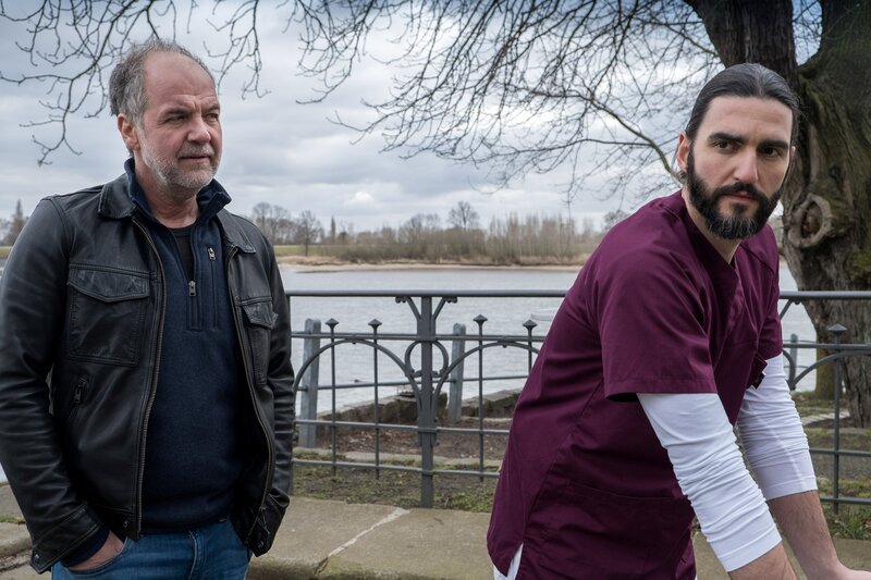 Oskar Schütz (Marek Erhardt, l.) befragt erneut den Pfleger Martin Rast (Dejan Bucin, r.). Irgendjemand hat am Vorabend spät seine Schlüsselkarte benutzt. – Bild: Manju Sawhney/​ZDF /​ ZDF Enterprises GmbH