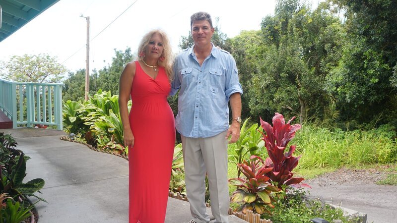 Home buyers Vikki Gaul (L) & Tom Gaul (R) standing on the walkup to the Hawaii Belt Rd house as seen on Hawaii Hunters (portrait) – Bild: Scripps.
