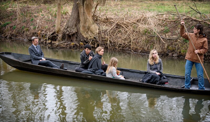 Maja Wichmann (Friederike Becht, r.) stagt mit ihren Persönlichkeiten, Toni (Yun Huang, 2.v.l.), Steffi (Anna Hermann, 3.v.l.), Theresa (Frida-Lovisa Hamann, 2.v.r.) und Kiki (Sibil Limird, 3.v.r.) zum Ort ihres Kindheitstraumas. Der Flüsterer (Philipp Hochmair, l.) behält alle im Blick. – Bild: ZDF /​ A.Thomaß