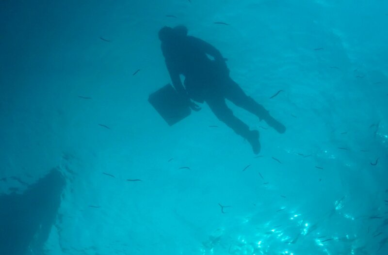 Nachstellung – Major Martins Leiche treibt auf dem Meer und ein Boot nähert sich. – Bild: phoenix/​Alizée Chiappini