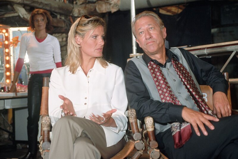 Carola (Eva Freese) und Horst Sommer (Nicolas Brieger) beobachten Beatrice beim Fotoshooting. Sie bemerken, dass Beatrice sehr nervös ist. – Bild: RTLplus