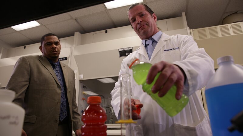 Chris Anderson observes Dr. Matthew C. Lee pouring a sports drink into a test tube. – Bild: Discovery Communications