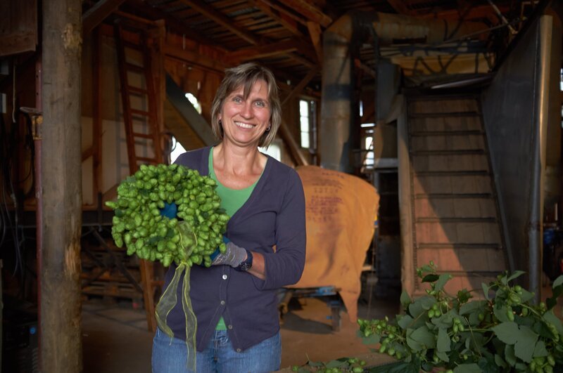 Gastgeberin Renate Schmidt mit einem selbstgeflochtenen Hopfenkranz. – Bild: BR/​megaherz gmbh