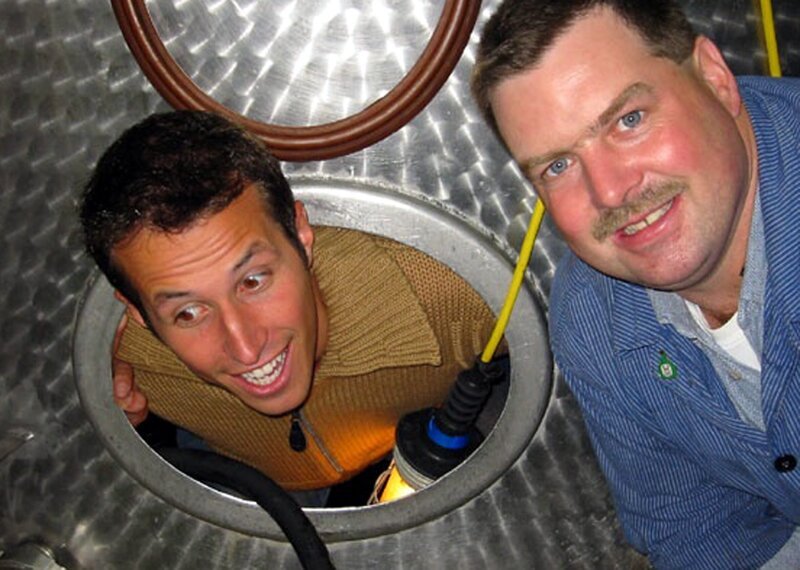 Willi Weitzel erfährt vom Winzer, wie der gewonnene Saft aus den gepressten Reben gefiltert, in große Tanks und zum Gären in große Fässer umgefüllt wird. – Bild: BR/​megaherz gmbh