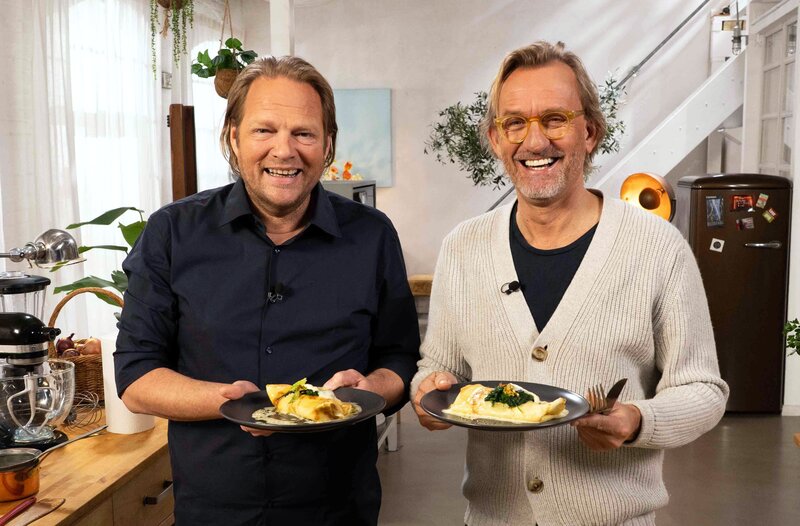 Spitzenkoch Frank Buchholz (r) serviert seinem Freund und Gastgeber Björn Freitag (l.) ein ganz besonderes italienisches Essen. Seine Crespelle sind reichhaltige Hausmannskost vom Feinsten! Pfannkuchen gefüllt mit Käse, Staudensellerie und Spinat werden in Sahnesoße drapiert und im Ofen überbacken. – Bild: WDR/​2Bild GmbH
