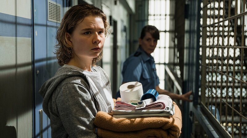 Die Freundin des Mordopfers auf dem Weg in die Zelle im Untersuchungsgefängnis: Daria Vivien Wolf als Mina Wirtz (l.) – Bild: SRF/​ZDF/​Daniel Dornhöfer