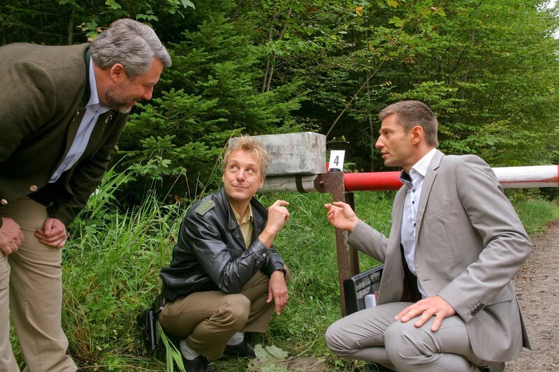 Für die Rosenheimer Ermittler Stadler (Dieter Fischer, l.), Mohr (Max Müller, M.) und Hansen (Igor Jeftic, r.) steht schnell fest, dass der Täter den Schlagbaum manipuliert hat. – Bild: ZDF/​Christian A Rieger