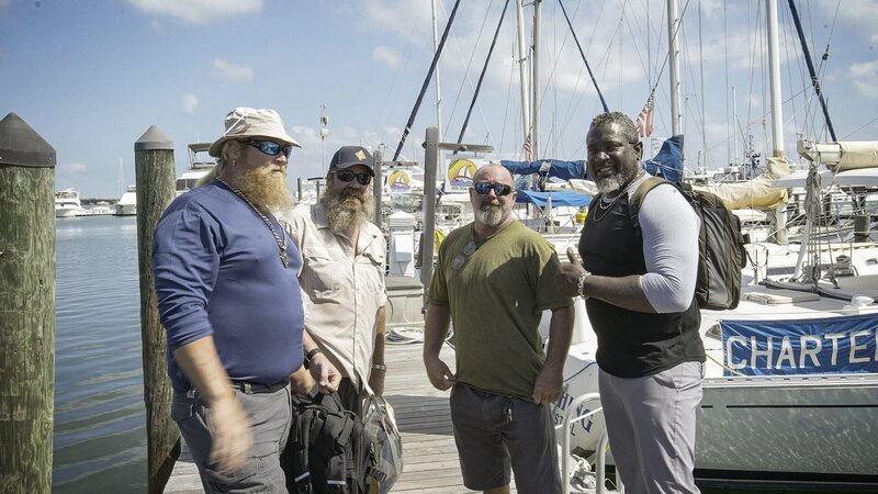Chuck Meier, Moe Mottice und Mike Still stehen neben dem Boot. – Bild: Warner Bros. Discovery