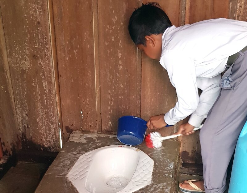 Manche Leuten sagen: „Reisen bildet“ oder „Hör auf dein Herz“. Das sagen die, weil Reisen und Erlebnisse bilden oder weil man sich am liebsten mit anderen guten Herzen verbindet und umgibt. Der kleine Philosoph Knietzsche will wissen, warum Güte, Ehre und Freundlichkeit vom Herzen kommen und warum man sich mit Bildung eine Meinung bilden kann. – Pheak beim Säubern der Schultoilette. – Bild: rbb/​visionX