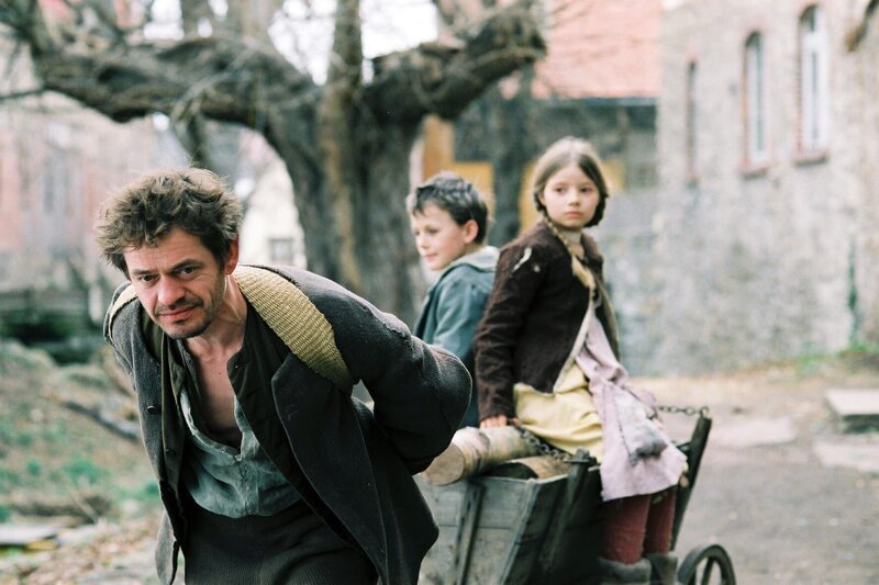 Hänsel (Johann Storm) und Gretel (Nastassja Hahn) werden vom Vater (Henning Peker) auf dessen Holzwagen nach Hause gezogen. Wieder hat der Vater kein Holz verkauft. – Bild: ZDF/Mario Pfeifer Hänsel (Johann Storm) und Gretel (Nastassja Hahn) werden vom Vater (Henning Peker) auf dessen Holzwagen nach Hause gezogen. Wieder hat der Vater kein Holz verkauft. – Bild: ZDF/Mario Pfeifer