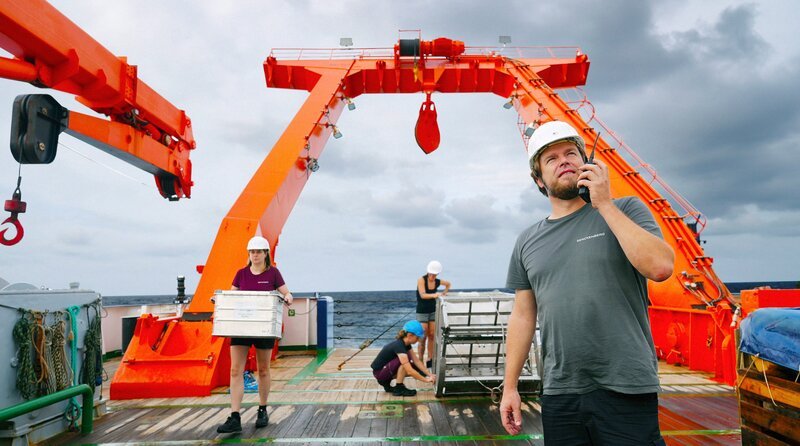 Tiefseeforscher Dr. Torben Riehl (Vordergrund) und Team bei der Arbeit an Deck. – Bild: HR/​Moritz Boll