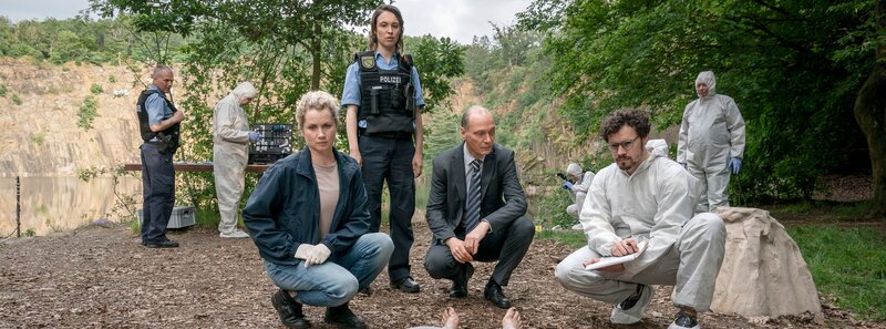 Leonie Winkler (Cornelia Gröschel, 3.v.l.), Polizistin Antje (Victoria Schulz, 4.v.l.), Peter Schnabel (Martin Brambach, 3.v.r.) und Dr. Himpe (Ron Helbig, 2.v.r.) inspizieren die Tote Lilly-Marie Reuter am Leichen-Fundort. – Bild: MDR/​MadeFor Film/​Steffen Junghans