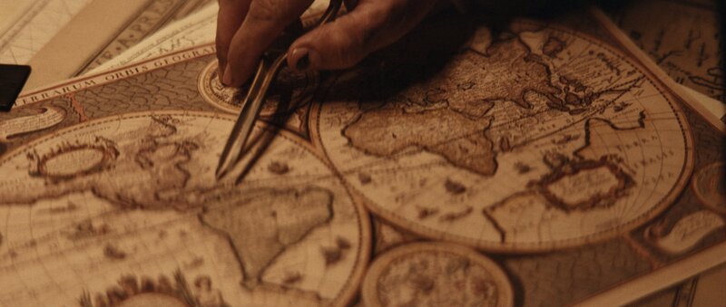 REENACTMENT – Francis Drakes Navigator schaut mit einem Messgerät in der Hand auf eine Karte. – Bild: Dash Pictures; Courtesy of Disney+