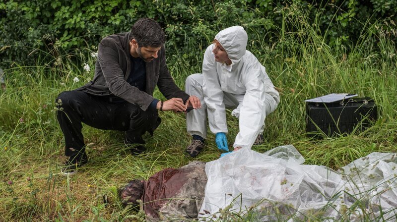Kommissar Dupin (Pasquale Aleardi) tauscht sich am Leichenfundort mit der Gerichtsmedizinerin (Nicole Beutler) aus. – Bild: ARD Degeto/​Wolfgang Ennenbach