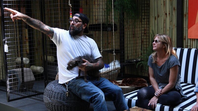 Host Antonio Ballatore holds his dog Edie while pointing to something with build crew member Christina Ray. – Bild: Discovery, Inc.