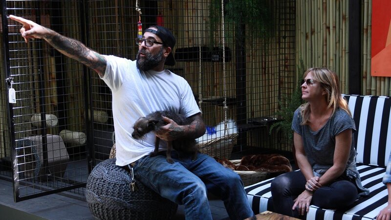 Host Antonio Ballatore holds his dog Edie while pointing to something with build crew member Christina Ray. – Bild: Discovery, Inc.