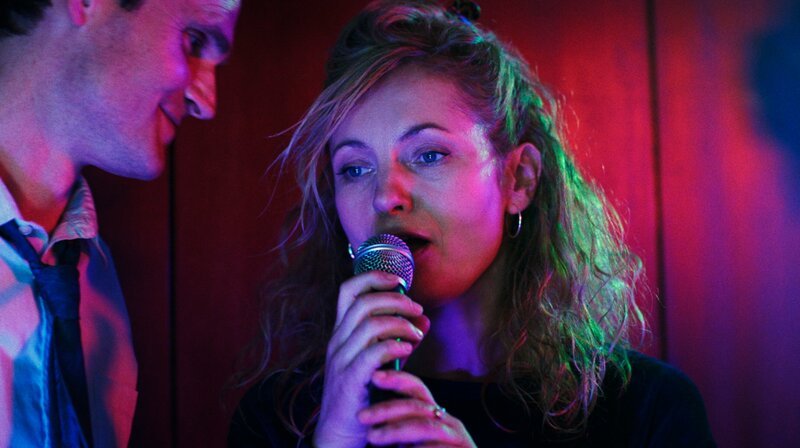 Karo (Naja Uhl, r.) und Peter (Fabian Hinrichs, l.) kommen sich beim Karaoke näher. – Bild: MDR/​ARD/​W&B Television GmbH/​Filmstill