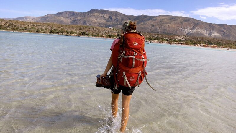 Eine Frau mit einem Rucksack auf dem Rücken läuft über das Meer – Bild: xplore
