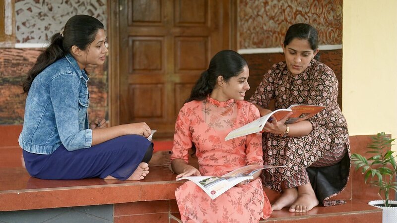 Deutschkurs schon in Indien – Aleena Johnson, Anjeetha Joseph und Vinaya Joseph mit Deutschkursunterlagen beim Farmhaus in den Cardamom Bergen. – Bild: ORF