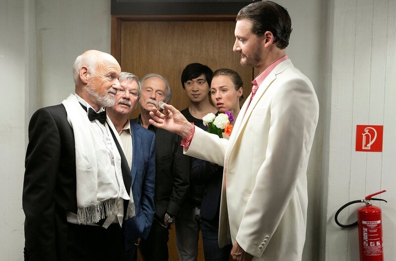 Günter (Wolfgang Winkler, 2.v.l.) und Edwin (Tilo Prückner, 3.v.l.) haben alle Mühe, aus den widersprüchlichen Aussagen des „Großen Maldini“ (Dietrich Hollinderbäumer., l.) und dessen Konkurrenten „Kalisto“ (Felix Rech, r.), die Wahrheit herauszufiltern. Hui Ko (Aaron Le, 3.v.r.) und Vicky Adam (Katja Danowski, 2.v.r.) sind beim Zusammentreffen der beiden Zauberer dabei. – Bild: MDR/​ARD/​Kai Schulz