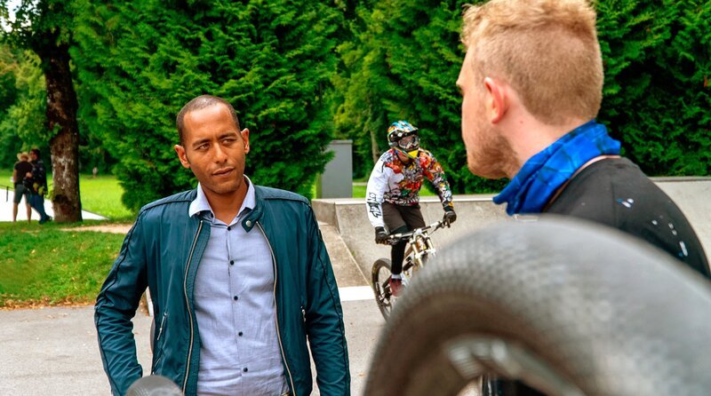 Jerry Paulsen (Peter Marton, l.) stellt Franz Grünberger (Johannes Berzel, r.) im Bikepark zur Rede. Franz streitet die Vorwürfe ab (mit Komparse). Weiteres Bildmaterial finden Sie unter www.br-foto.de. – Bild: ARD/​Lucky Bird Pictures/​Savoy Film Productions
