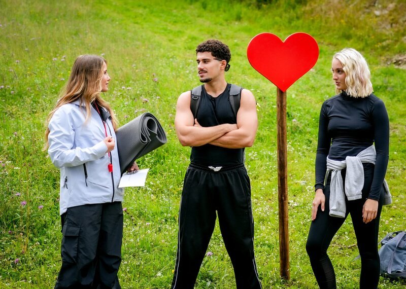 Kupplerin und Schiedsrichterin Michelle Pippan erklärt Kandidat Caire und Single Ina ihren bevorstehenden Beziehungstest: ein Partner Workout. – Bild: ORF/​TVfriends