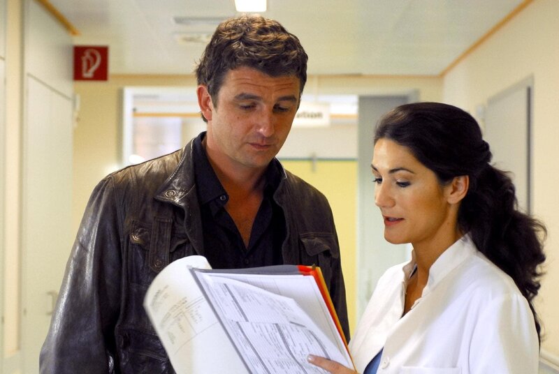 Julia (Mariella Ahrens) zeigt Martin (Hans Sigl) erste Untersuchungsergebnisse. Sie zweifelt an der Krebsdiagnose, die bei Jörg gestellt wurde. – Bild: ORF/​ZDF/​Hans Seidenabel
