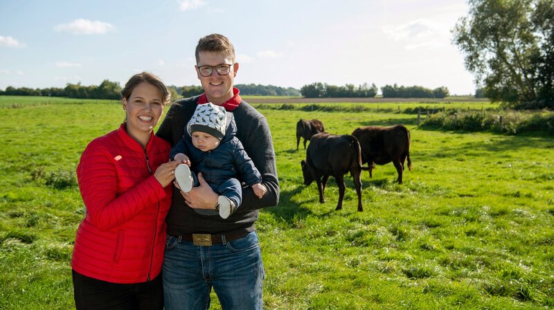 Die dritte Land und lecker-Reise geht in den Norden zu Marisa Marquardt (l) – hier mit ihrem Mann Fynn und Sohn Felix. Auf dem Hof Holstein-Wagyu in Negenharrie in Holstein werden Wagyu-Rinder gezüchtet. – Bild: WDR/​Melanie Grande