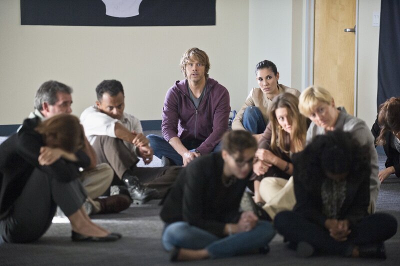 Gemeinsam versuchen sie, die Terroristen, die ein Bürogebäude mit Geiseln eingenommen haben, zu stoppen, in dem sie sich heimlich unter die Geiseln mischen: Kensi (Daniela Ruah, hinten r.) und Deeks (Eric Christian Olsen, hinten l.) … – Bild: CBS Studios Inc. All Rights Reserved.