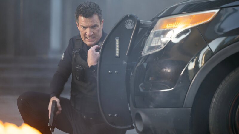 Officer Nolan (Nathan Fillion) gerät in Lebensgefahr, als neben ihm ein Geldtransporter explodiert und es zu einem Schusswechsel kommt. – Bild: ZDF und Raymond Liu