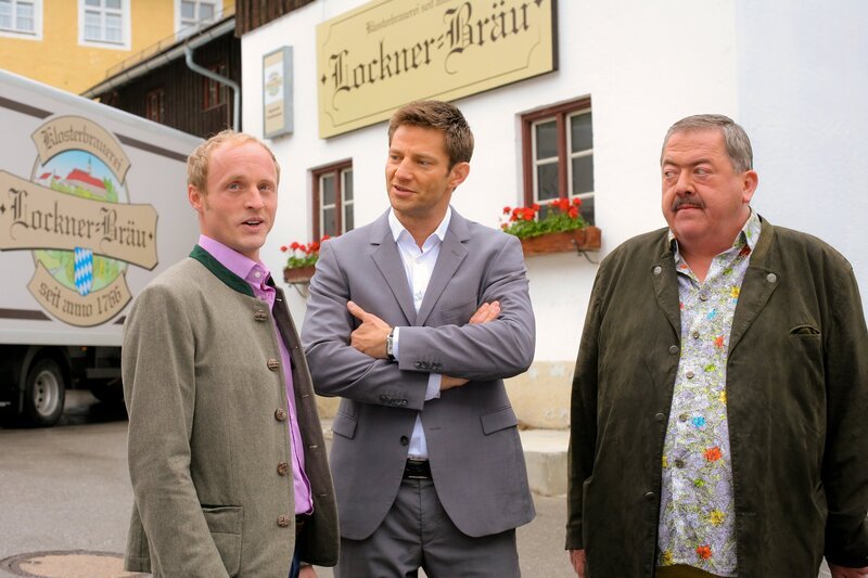 Nachdem die Kommissare Hansen (Igor Jeftic, M.) und Hofer (Joseph Hannesschläger, r.) herausfinden, dass das Opfer seinen Sohn enterben wollte, gerät Timm Lockner (Florian Brückner, l.) in Erklärungsnöte. – Bild: ZDF/​ZDF/​Bavaria Fernsehprod./​Christi