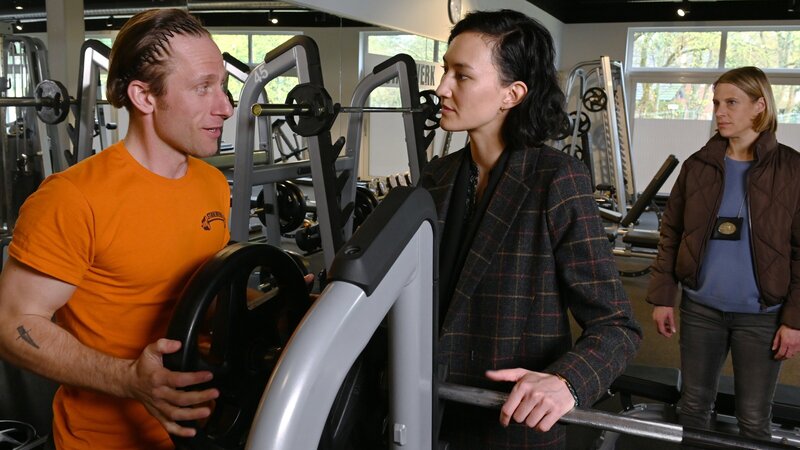 Pauline Hobrecht (Agnes Decker, M.) und Tamara Meurer (Anja Pahl, r.) fahren zum letzten Arbeitsplatz des Toten. Er arbeitete im Fitnessstudio von Marco Stahl (Merlin Leonhardt, l.) als Aushilfe. – Bild: ZDF und Andre Kowalski