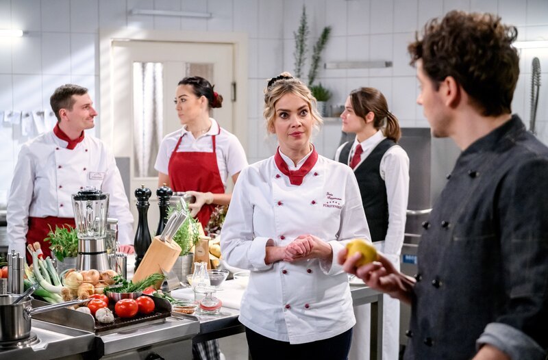 Kilian (Anthony Paul, r.) versichert Greta (Laura Osswald, m.), dass er sein exklusives Menü auch für eine Hochzeitsgesellschaft kochen kann. – Bild: ARD/​WDR/​Christof Arnold
