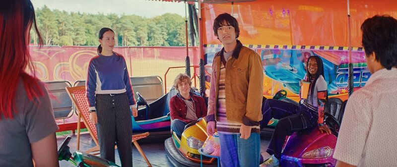 Die Erdrutschgruppe – Dev (Kalli Tant), Kai (Charlie Banks), Jay (Noah Manzoor) und Meena (Florisa Kamara, hinten – v.l.n.r.) – ist verblüfft, dass die die Libellen-Gruppe in ihrer virtuellen Welt auftaucht. Kaz (Maiya Silveston, v.l.) und Glen (Krish Misra, v.r.) haben viele Fragen zum Rummelplatz. – Bild: ZDF/​Stefan Hill